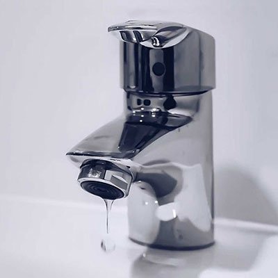 Professional plumber fixing kitchen sink faucet