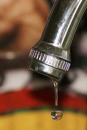 Professional plumber fixing kitchen sink faucet