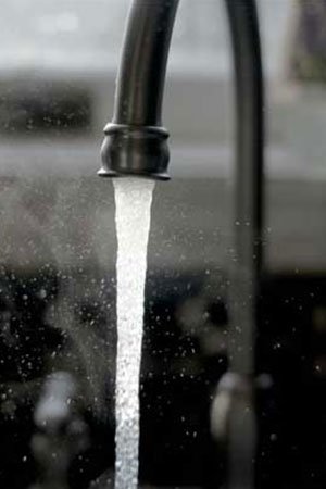 Professional plumber fixing kitchen sink faucet